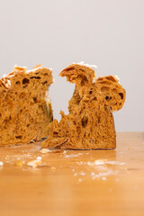 Torn slice of traditional Italian leavened cake showing a soft, fibrous and airy crumb, photographed on a rustic wooden table. © Vincenzo VAD