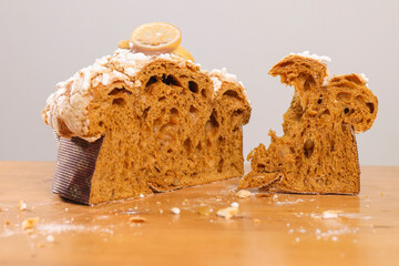 Artisanal Italian Easter cake cut open with a torn slice beside it, showing the fluffy internal texture, candied fruit pieces and sugar-crusted top. © Vincenzo VAD