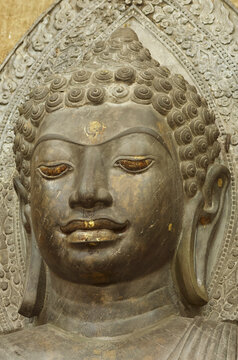 Close-up of the serene face of ancient green stone Buddha statue at Wat Na Phra Meru, Ayutthaya, Thailand