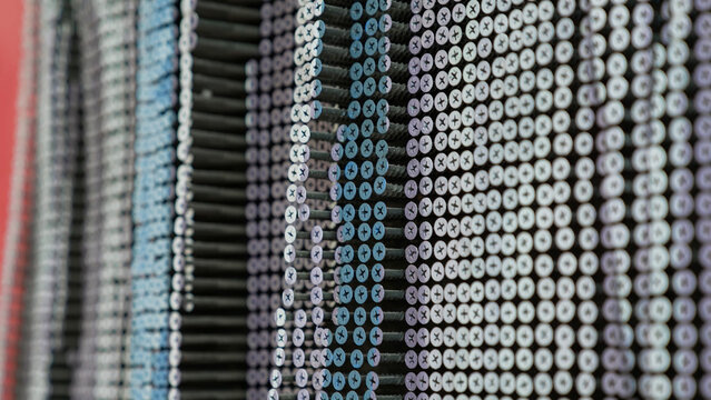 Close-up abstract pattern of rows of industrial screws or fasteners