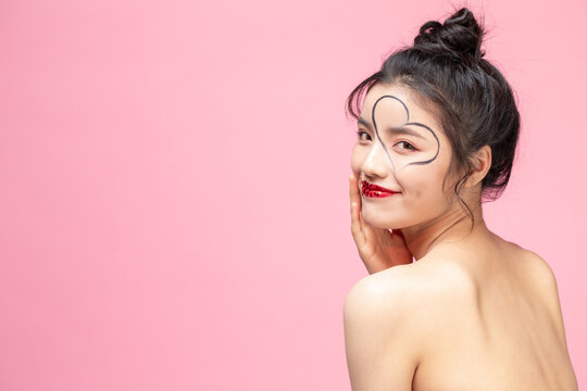 Woman with Heart Shape on Face and Red Sequin Lips on Pink Background