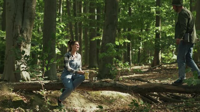 Couple Having Coffee Break on Tree Log During Forest Hike