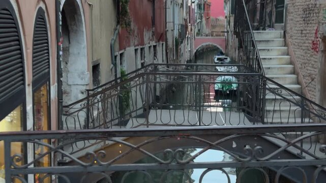Tourist Boat Gliding Beneath Ornate Bridge in Venice Canal
