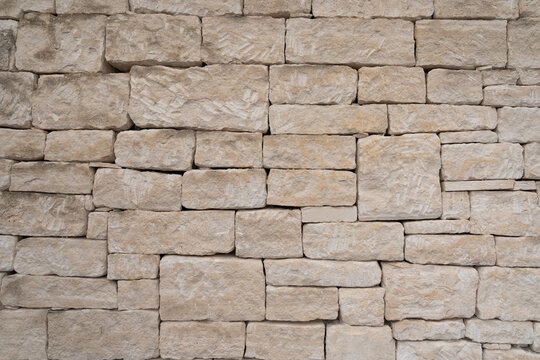 Weathered limestone wall built from rough hand cut stone blocks