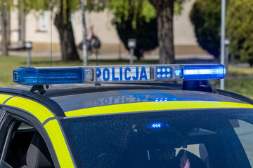 Policjant biegnie do radiowozu na akcję © FotoDax