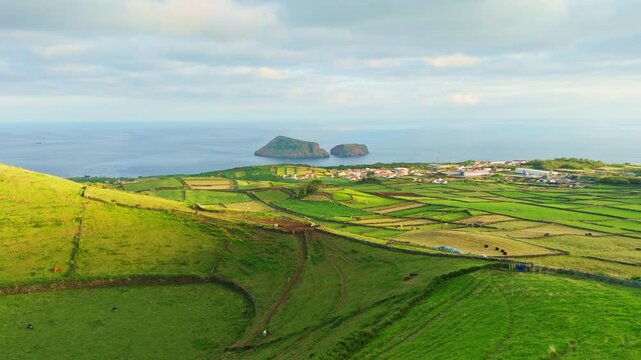 Pico Dona Joana Volcanic Cone, Patchwork Fields, Pasturelands and Cabras Islets at Sunset. Atlantic Ocean. Terceira Island, Azores, Portugal. Aerial View. Moving Backwards and Upwards
