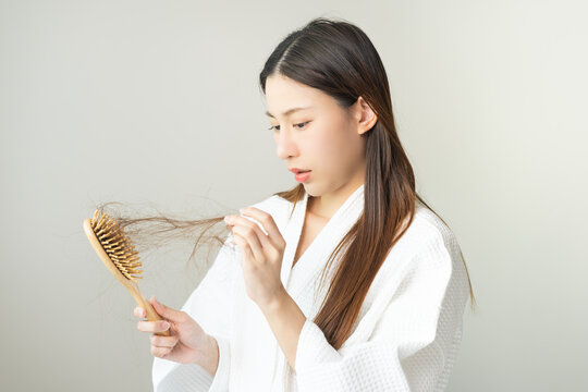 Stress asian young woman, girl hand holding comb show her hairbrush with loss, hair in brush after brushing, hair fall out problem. Health care, beauty with treatment concept, isolated on background.