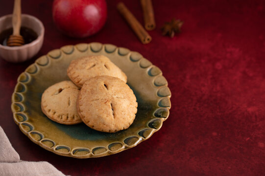 Mini apple pies with honey dipper and cinnamon sticks, autumn baking