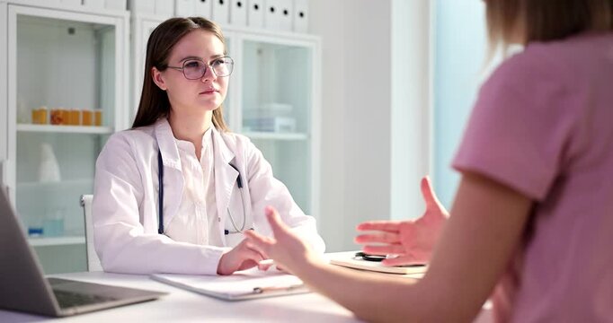 A patient engages in a thorough conversation about health concerns with a clinician in a well-lit, modern clinic. The atmosphere is professional and inviting.