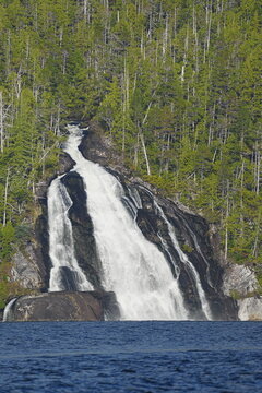 Waterfall cascading through forested hillside