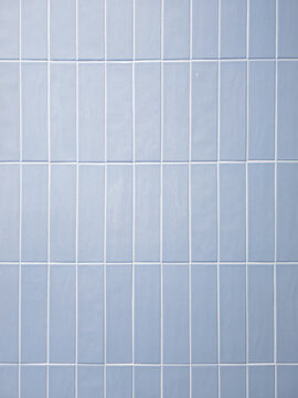 Light blue ceramic tile wall background. Modern minimalist interior design texture with clean white grout lines. Perfect architectural background for home decor and modern spaces.