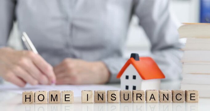 Participants explore key concepts of home insurance as they write notes and review related materials. A miniature house model adds context, enhancing clarity on important terms.