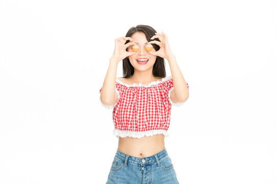 Happy young woman holding macarons over eyes like glasses on white background