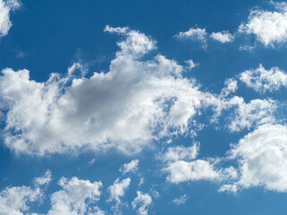 Obraz premium Blue sky with white and grey clouds forming a natural atmospheric cloudscape.