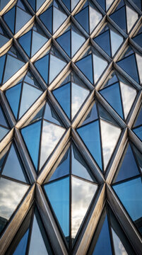 Diamond-faceted glass tower facade forms an abstract geometric downtown pattern