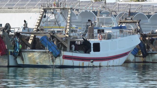 Commercial trawler fishing boat moored at harbor front pier