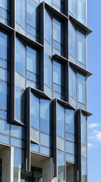 Faceted glass facade catches daylight in a sharp geometric abstract building pattern