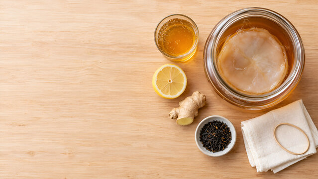Homemade kombucha with SCOBY and ingredients viewed from above with copy space