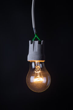 Glowing vintage light bulb close up on black background