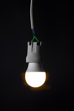 Glowing  light bulb close up on black background