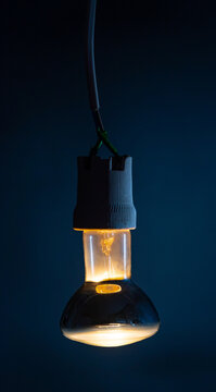 Glowing  light bulb close up on black background