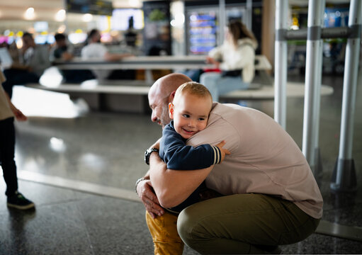 Father and young son sharing happy reunion hug at airport
