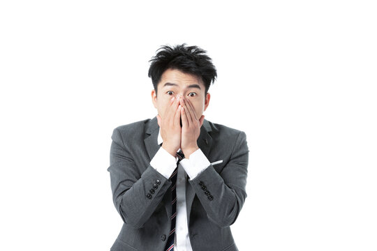 Shocked Asian Businessman in Suit Covering Mouth with Hands on White Background