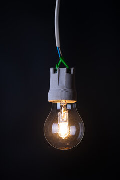 Glowing vintage light bulb close up on black background