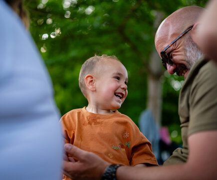 Father and smiling toddler boy having fun outdoors