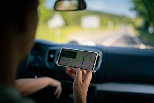 Driver navigating rural road using smartphone gps map
