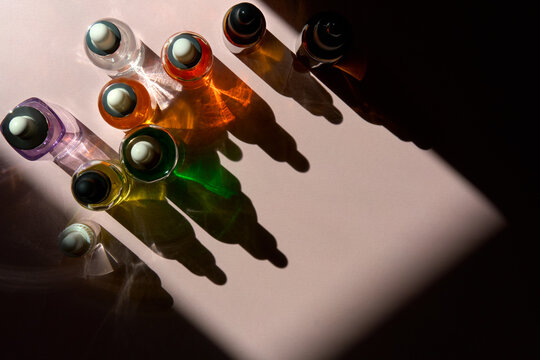 Colorful Serum Dropper Bottles in Sunlight and Shadows with Copy Space