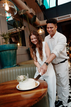 Just Married Couple Cuts Cake Together in Restaurant