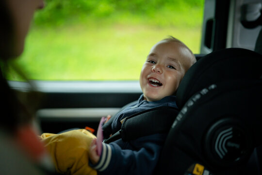 Smiling toddler enjoying a happy car ride in safety seat