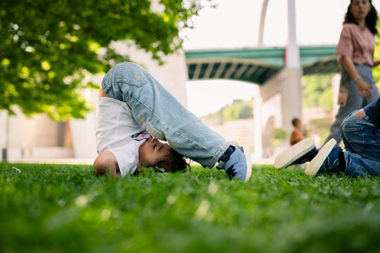 Young child somersaulting on grass in park