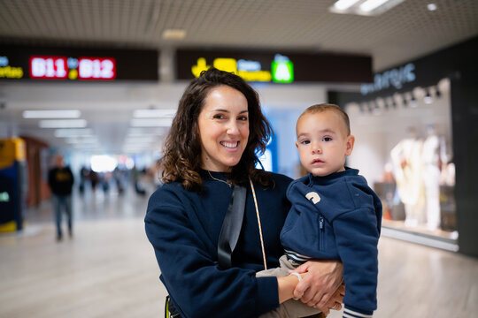 Mother holding son traveling through airport terminal