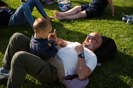 Father bonding with baby son on green grass