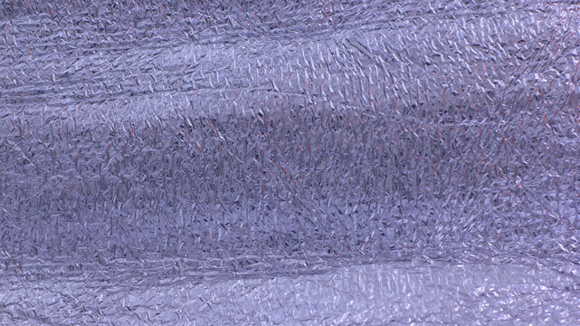 Crumpled aluminum foil insulation material texture background, reflective metallic thermal packaging sheet surface close up.