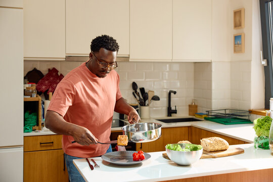 Man works in his kitchen, preparing a tasty meal