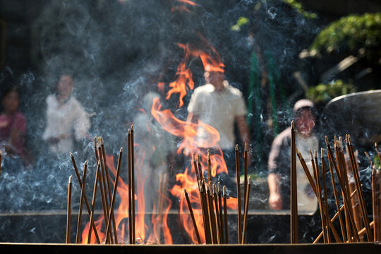 Closeup of burning incense in a large burner at an Eastern temple