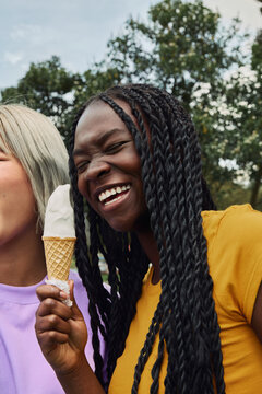 Happy young woman enjoying a sweet ice cream cone