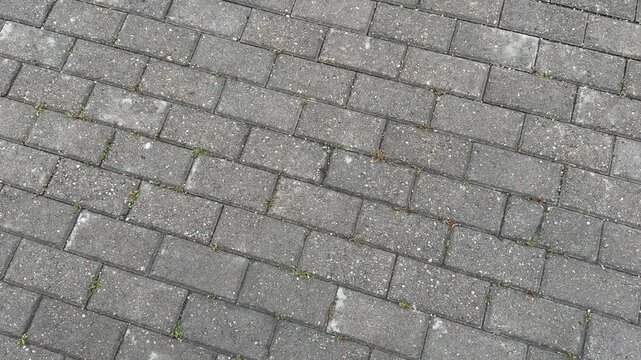 Top view texture of grey rectangular paving stones on a sidewalk. Urban pavement design, outdoor ground texture.