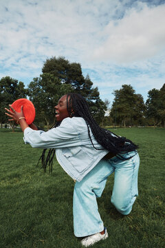 Young woman catching a frisbee in park on sunny day