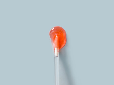 Orange lollipop on a light blue background