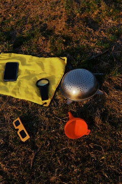 Outdoor setup for watch eclipse on a yellow mat with tools and phone