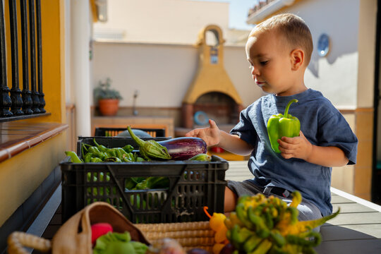 Toddler next to fresh vegetables