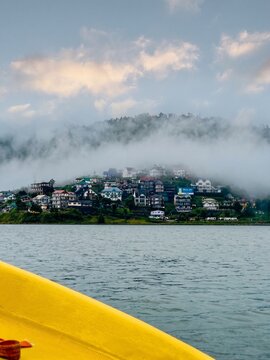 Scenic view of Lake Gregory and misty hills with colorful houses in Nuwara Eliya, Sri Lanka