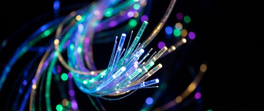 Colorful fiber optic cables glowing against a dark background  