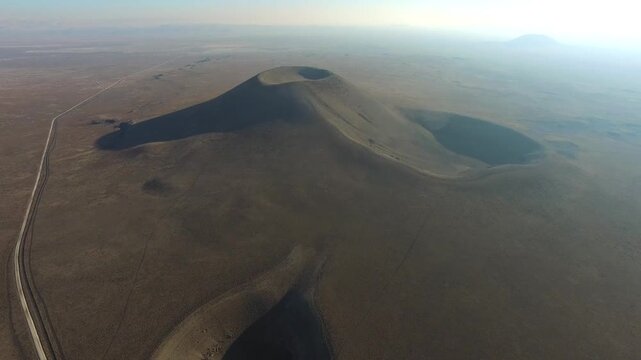 Large sinkhole opens in flat plain, circular ground collapse exposing deep geological cavity.