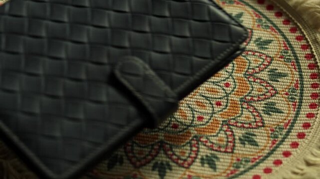 Hand placing blue pen on woven leather notebook, business still life