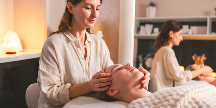 Woman receiving a gentle head massage at spa, illustrating neurowellness, nervous system regulation, stress relief, therapeutic touch, relaxation and holistic wellbeing.